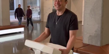 Elon Musk entra sonriente a la sede de Twitter con un lavamanos
